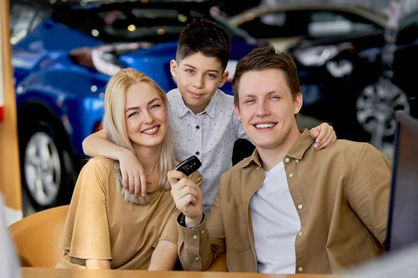 Retrato de clientes sorridentes segurando chaves por carro novo — Fotografia de Stock