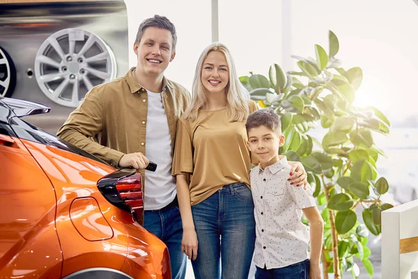 Hermosa familia feliz obtener llaves por su nuevo coche — Foto de Stock