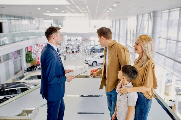 Vendedor Affable consultar clientes na concessionária de carros — Fotografia de Stock