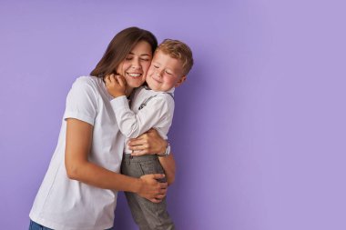 Sevecen anne ve oğul, mor arka planda izole edilmiş.