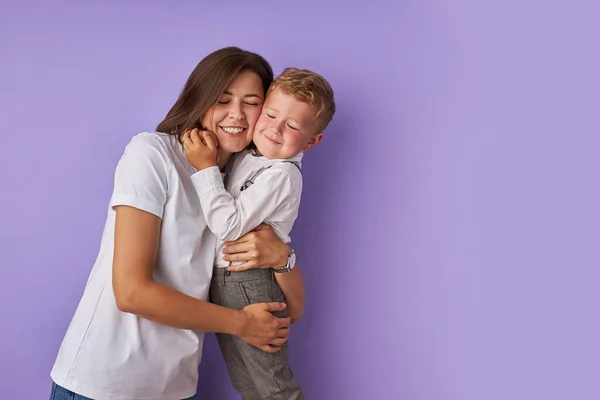 Mère affectueuse et fils isolé sur fond violet — Photo