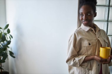 Genç ve güzel siyah bayan bir fincan çay içer.