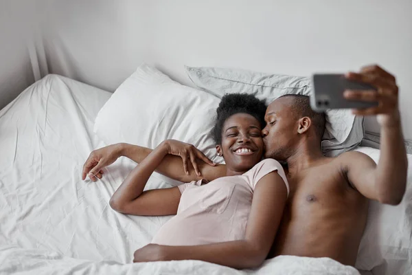 Расслабленной паре сделать селфи на кровати — стоковое фото