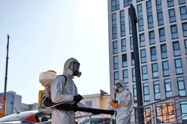 Disinfector in protective suit processes territory of streets, sprays poison from pests — Stock Photo, Image