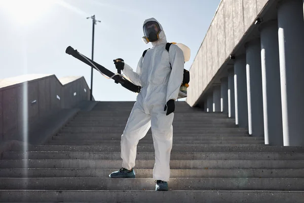 Hombre de traje blanco y protegido con desinfectante limpia las calles —  Fotos de Stock