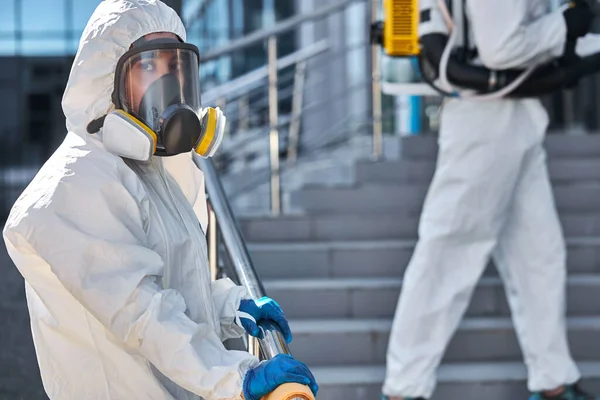 Especialistas en trajes de materiales peligrosos limpieza desinfectar las células del coronavirus epidemia, pandemia riesgo para la salud —  Fotos de Stock