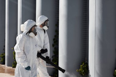 Tehlikeli madde giysileri uzmanları koronavirüs hücrelerini dezenfekte ediyor, salgın hastalık riski var.