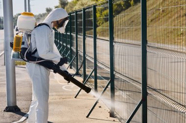 Tehlikeli Maddelerde çalışan genç bir temizlikçi ve dışarıda çamaşır makinası var.