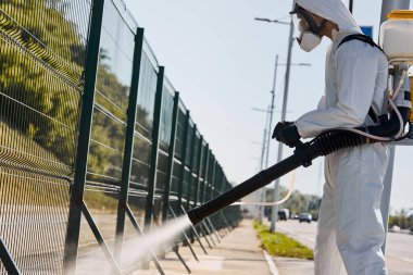 Tehlikeli Maddelerde çalışan genç bir temizlikçi ve dışarıda çamaşır makinası var.