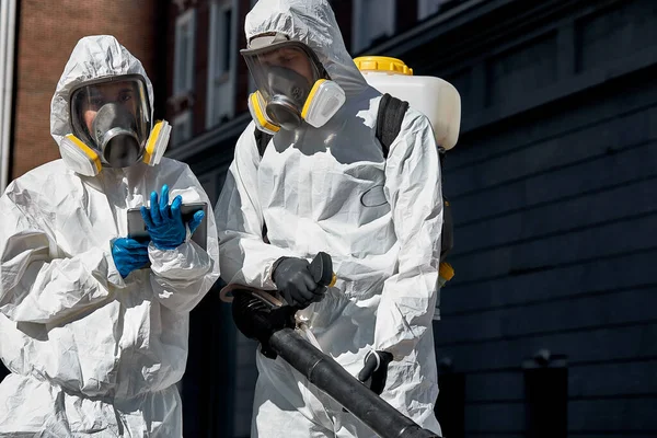 Brave personnel de nettoyage en costume de biosécurité, masque et gants, effectue la désinfection du coronavirus — Photo