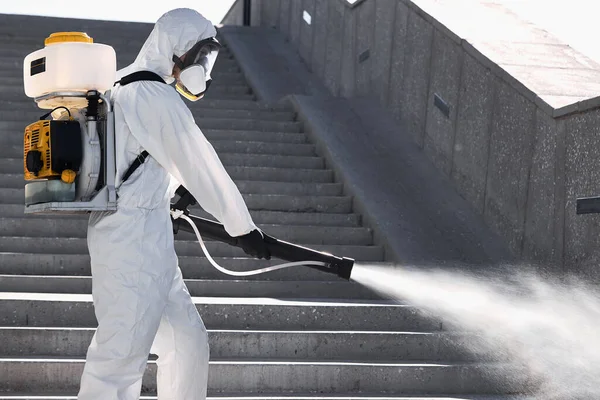 Απολυμαντικό σε προστατευτική αντιική στολή, φιάλη ψεκαστήρα χημικής απολύμανσης σε εξωτερικούς χώρους — Φωτογραφία Αρχείου