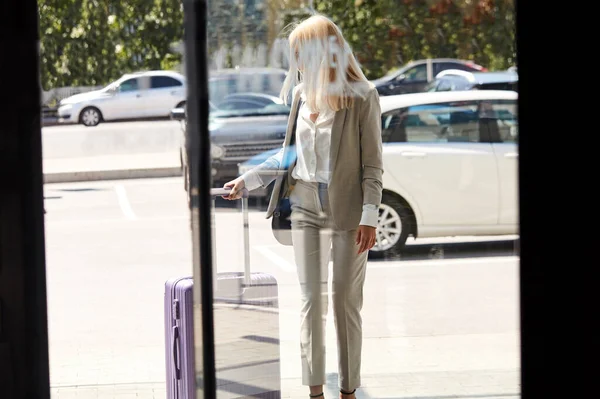 blonde business lady entering hotel