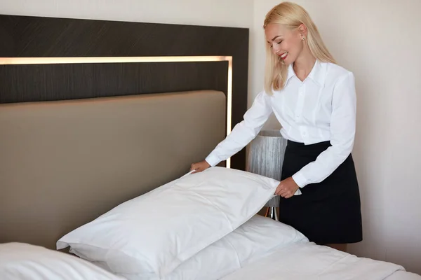 Nice maid prepares a bed for guests — Stock Photo, Image