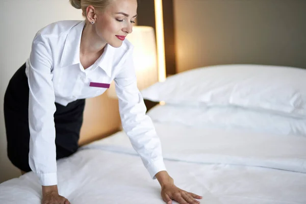 Female chambermaid making bed in hotel room — Stock Photo, Image