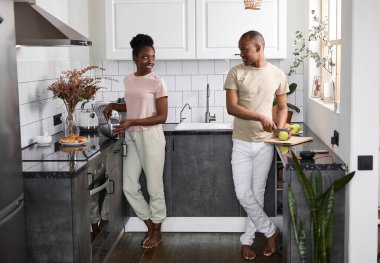 Yakışıklı adam karısının kahvaltı hazırlamasına yardım ediyor.