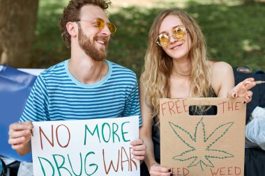 legalize marijuana. manifestation. two caucasian adults holding banners and placards clipart