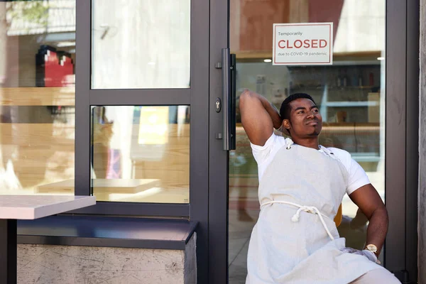 Black waiter of street cafe is waiting for clients, customers — Stock Photo, Image