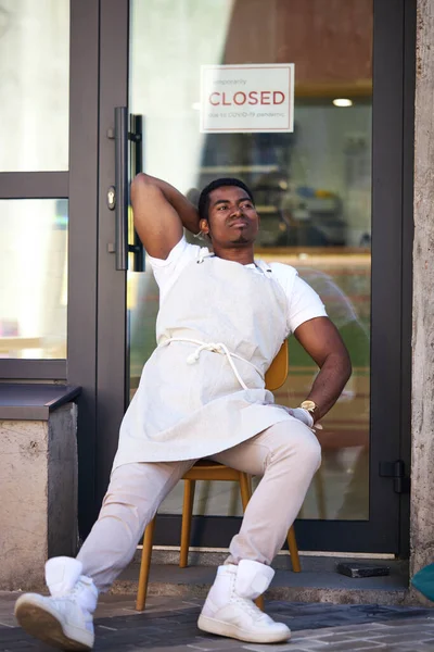 Homem perturbado sentado na rua, sua loja de café está batendo — Fotografia de Stock