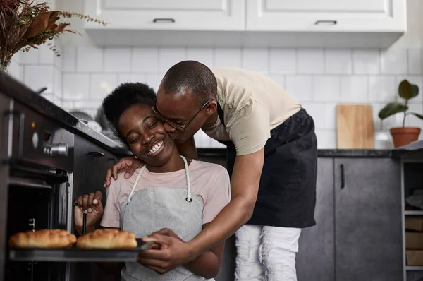 Negro hombre besa esposa para cocer pasteles, gracias a ella —  Fotos de Stock