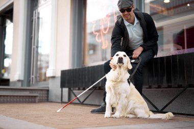 25 yaşındaki adam körlükten muzdarip, köpek rehberinden yardım alıyor.