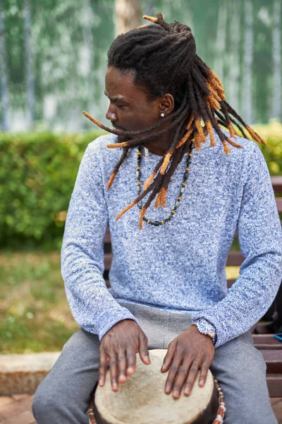 Joven afro hombre con djembe tambores al aire libre — Foto de Stock