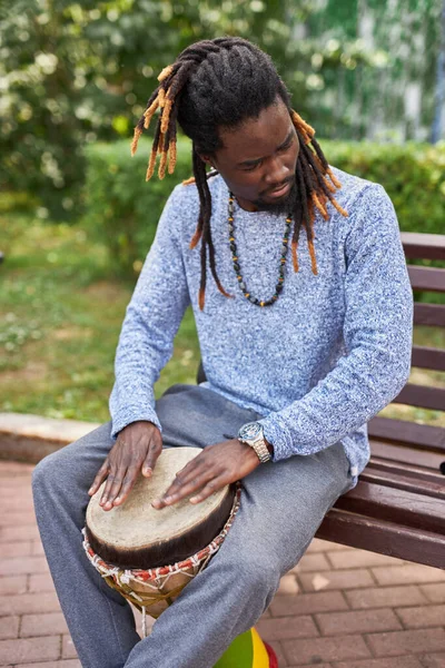 Músico de pele escura toca bateria ao ar livre — Fotografia de Stock