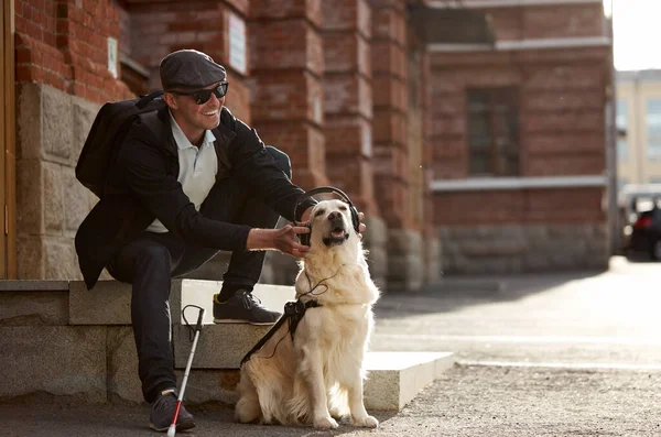 Feliz ciego macho entretiene a su perro guía —  Fotos de Stock