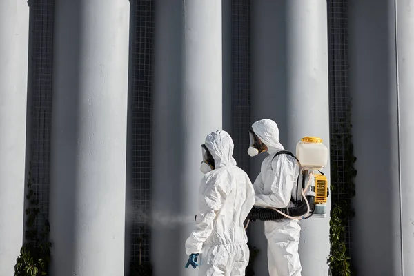 lets clean, disinfect this places. two cleaners in suits work together