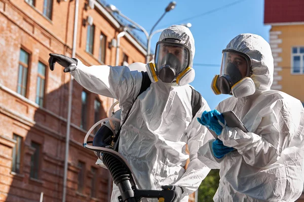 Specialister på hazmat passar rengöring desinficera coronavirus celler epidemi, pandemisk hälsorisk — Stockfoto