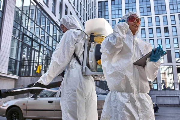 Specialists in hazmat suits cleaning disinfecting coronavirus cells epidemic, pandemic health risk — Stock Photo, Image