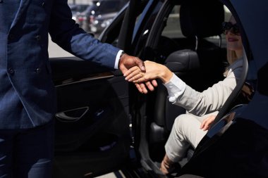 Kibar taksi şoförü iş kadınının arabadan inmesine yardım etti.