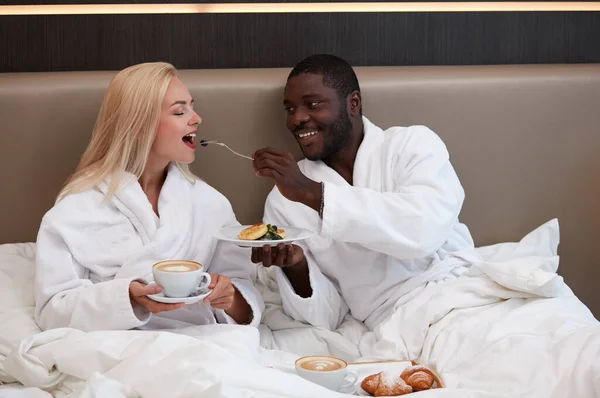 adorable multiethnic couple have breakfast in hotel