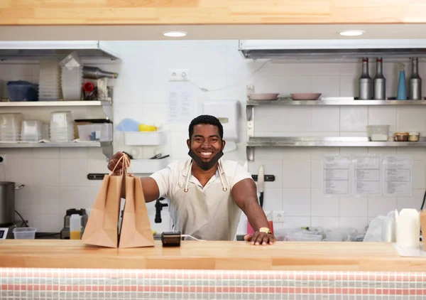 handsome affable black cafe staff prepared takeaway orders