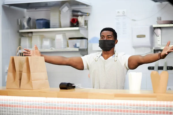 Trabalhador café preto fica com os braços abertos — Fotografia de Stock