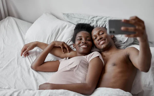 Расслабленной паре сделать селфи на кровати — стоковое фото