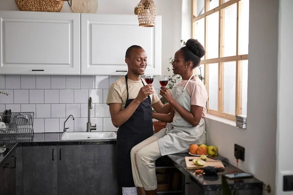 Afroamericanos recién casados beber vino mientras cocina —  Fotos de Stock