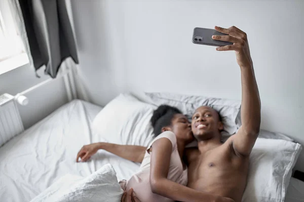 Mooi getrouwd stel nemen selfie op bed — Stockfoto