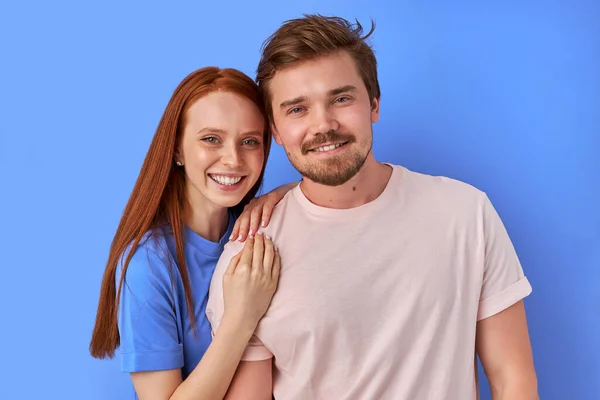 Positief Kaukasisch paar geïsoleerd over blauwe achtergrond — Stockfoto