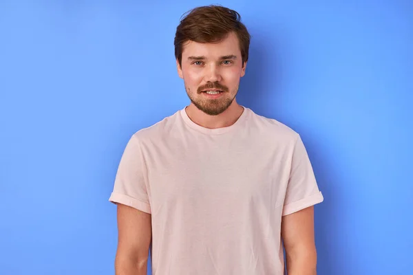 Zelfverzekerde rustige man in t-shirt poseren op camera geïsoleerd — Stockfoto