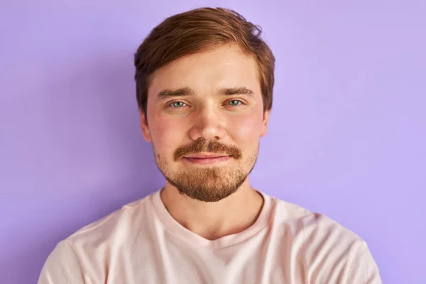 Zelfverzekerde rustige man in t-shirt poseren op camera geïsoleerd — Stockfoto