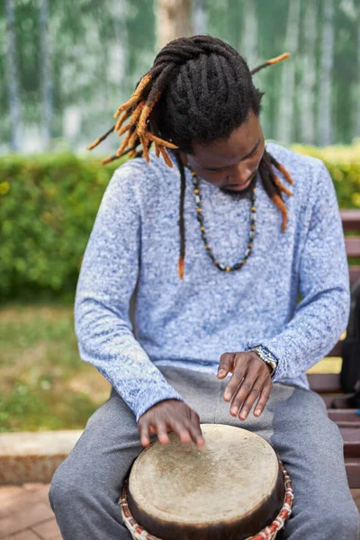 Busker man performs music using djembe — Stock Photo, Image