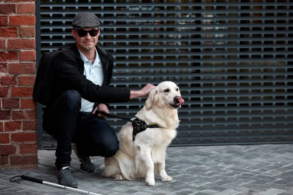 blind man stroke his helpful dog guide