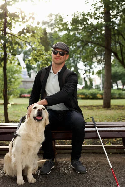 身体障害者は屋外の盲導犬と一緒に休んでいる — ストック写真
