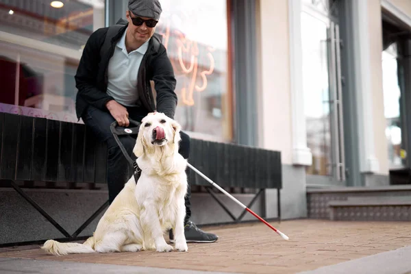 blind man lovingly stroking do, feeling gratitude for help