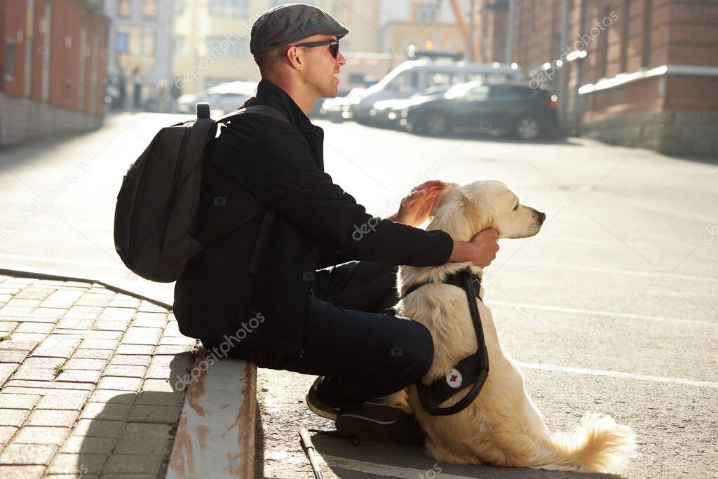 blind man stroke his helpful dog guide