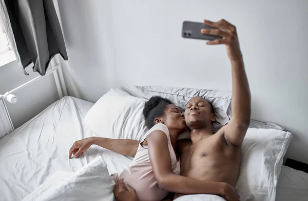 Gelukkig getrouwd paar nemen selfie op bed — Stockfoto