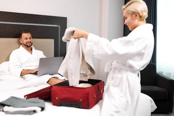 Handsome guy with laptop look at wife in bathrobe — Stock Photo, Image