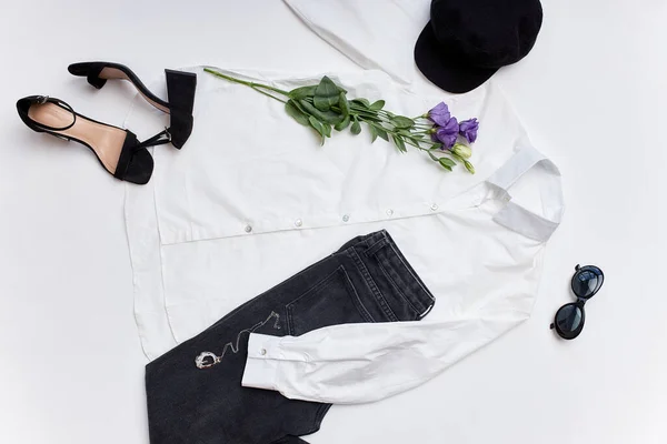 Płaskie damskie ubrania i akcesoria.Biała bluzka, czarne spodnie, buty, kapelusz i okulary przeciwsłoneczne — Zdjęcie stockowe