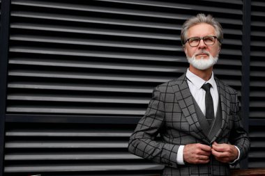 Olgun iş adamı dışarıda kıyafet ayarlama düğmesi