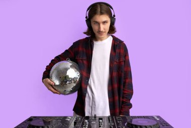 Sesi kontrol etmek ve müzik çalmak için karışık ekipmanlı şık bir DJ erkek.